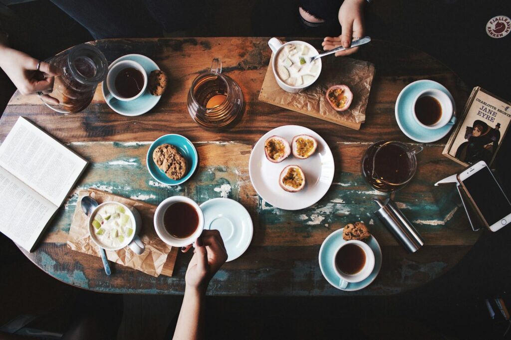 Best Cafes in Cairns, Overhead view of a cozy coffee table setup with cups, snacks, and books, perfect for a relaxing afternoon.