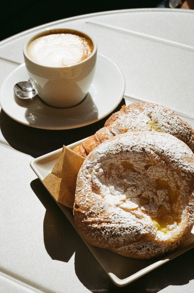 Best Cairns Cafes, A couple of doughnuts on a plate next to a cup of coffee