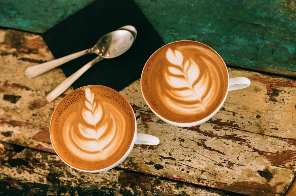 Best Cairns Cafes, Café latte art on rustic table in Paris, capturing warm coffee moments.