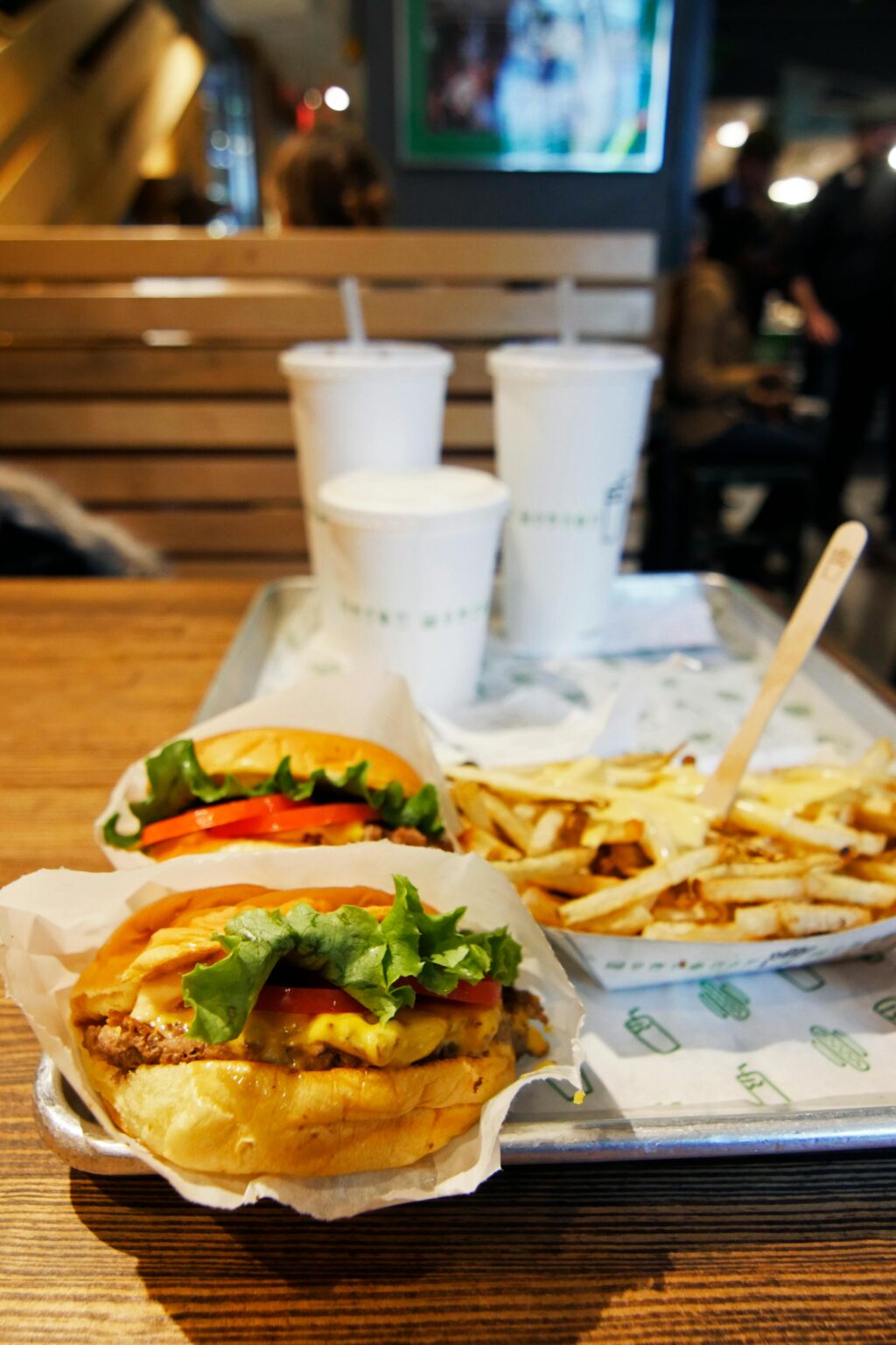 Savor a mouth-watering burgers and fries combo with refreshing drinks in a cozy restaurant setting.